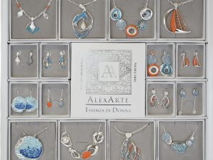 Espositore della collezione "Sunrise" di Alexarte, con parure di collane e orecchini anallergici. Gioielli eleganti in blu e arancione, perfetti per ogni occasione. Design raffinato e materiali di alta qualità, ideali per pelli sensibili.